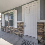 Exterior of a house with gray and stone veneer siding