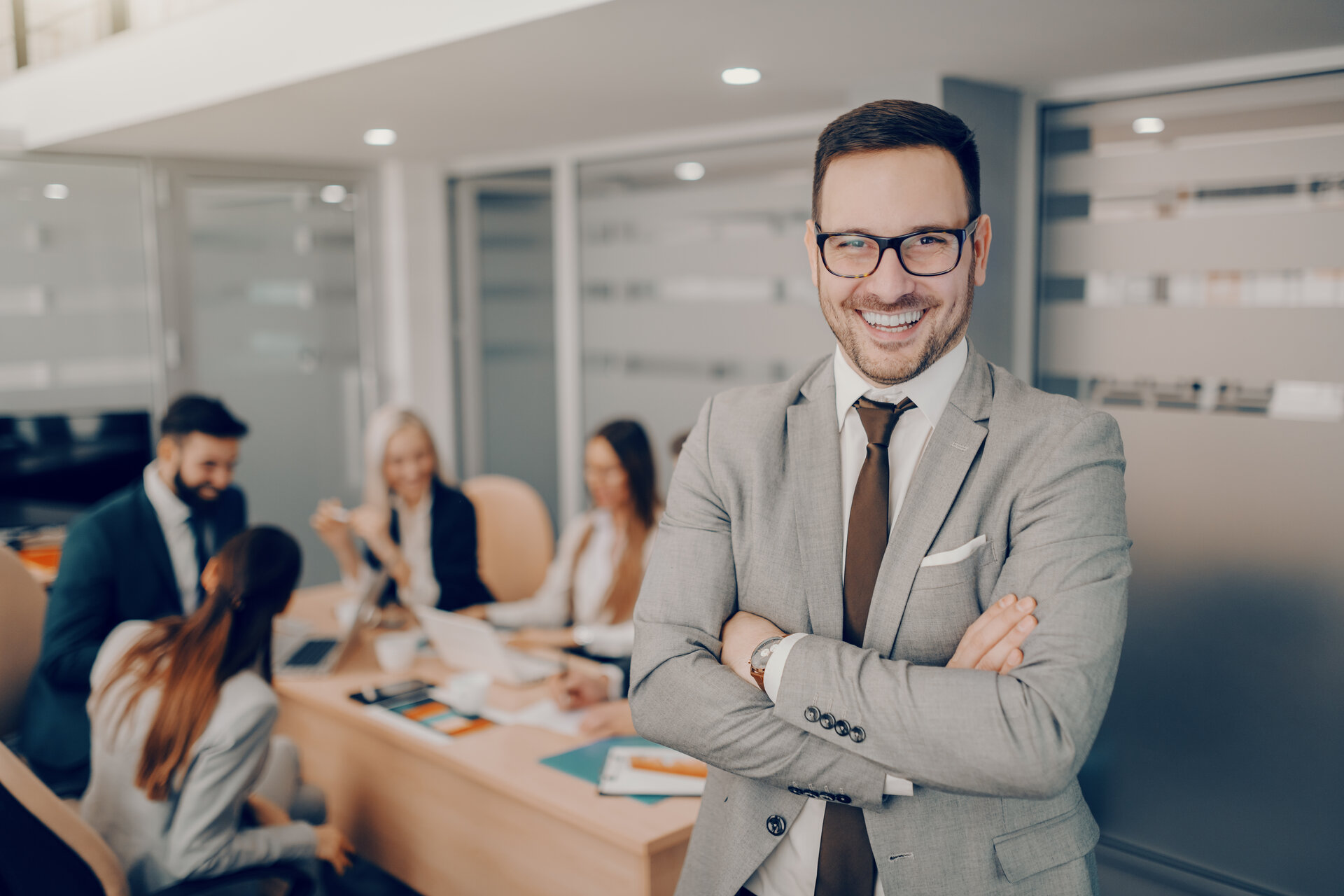 Handsome smiling businessman in formal wear and eyeglasses stand