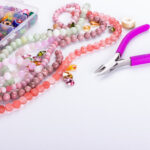 Rose quartz beads for beadwork on white background. Hobby, handmade, fine arts. Selective focus
